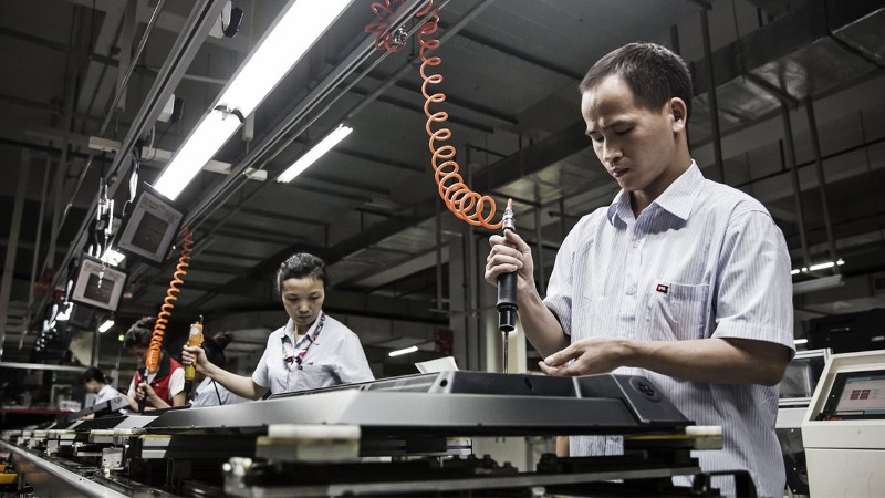 Workers assemble monitors at a factory in Huizhou, Guangdong province