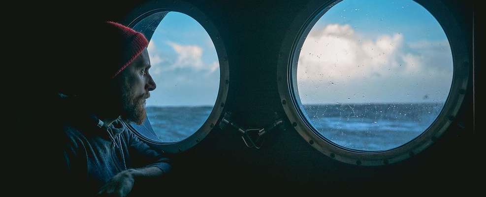 Man on boat looking out of windows - Photo:Innovation Norway