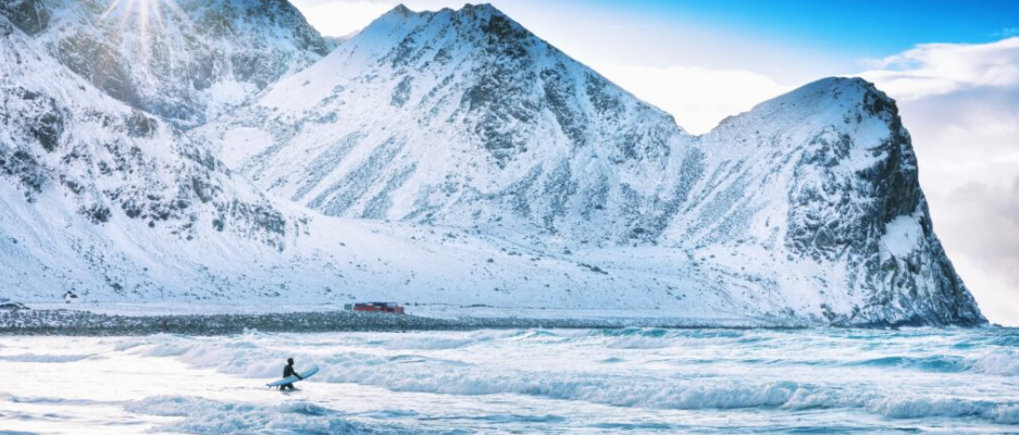 Bilde av en person som surfer i Lofoten på vinteren - Foto:Foto: Adobe Stock