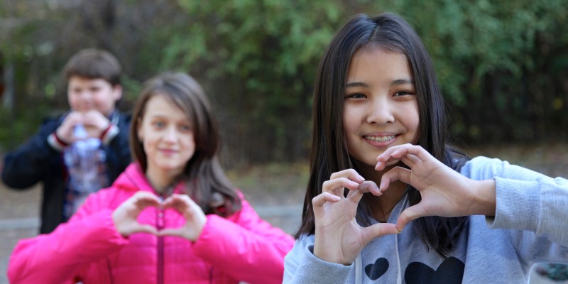 Children holding heart signs