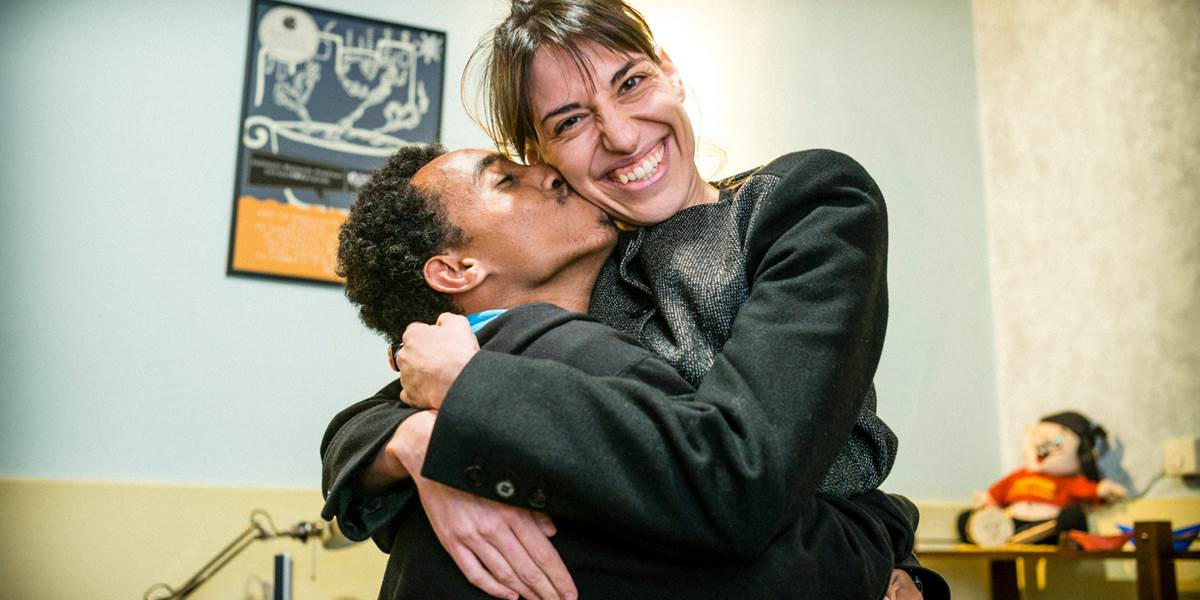 Young man and boy hugging