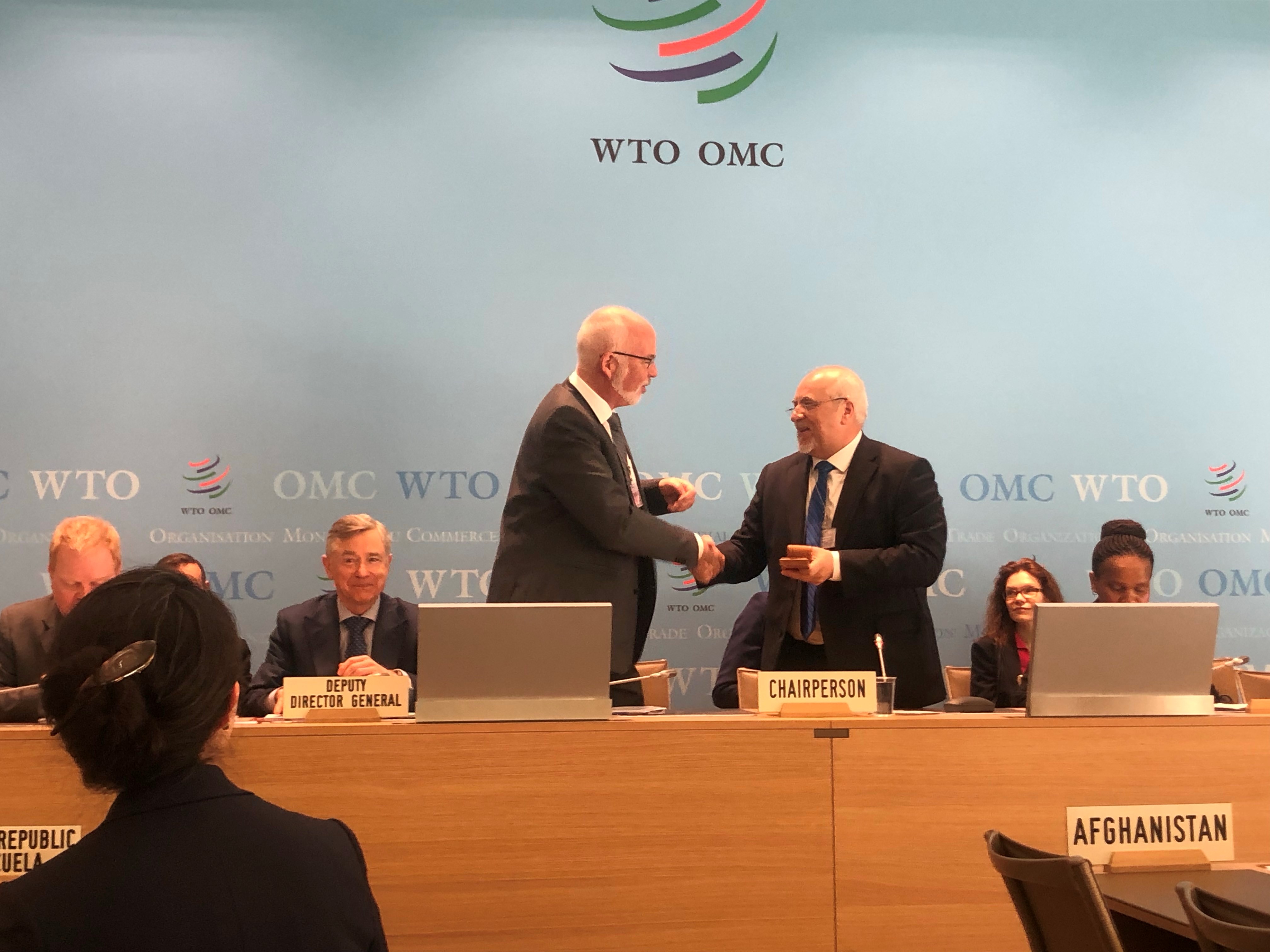 Incoming chair, Dagfinn Sørli, receives the ceremonial gavel from a former chair, Ambassador Peter Brňo