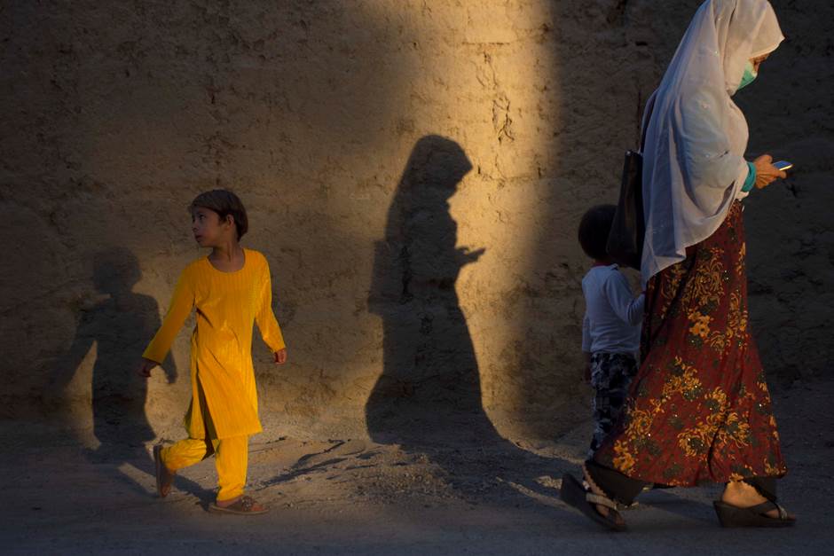 A mother and her children pass by one of the streets of Kabul on a casual day, 2019.