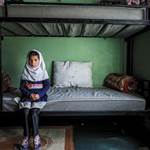An Afghan girl sitting on her bed at Herat Orphanage Center unwilling to talk, even speak of her nam