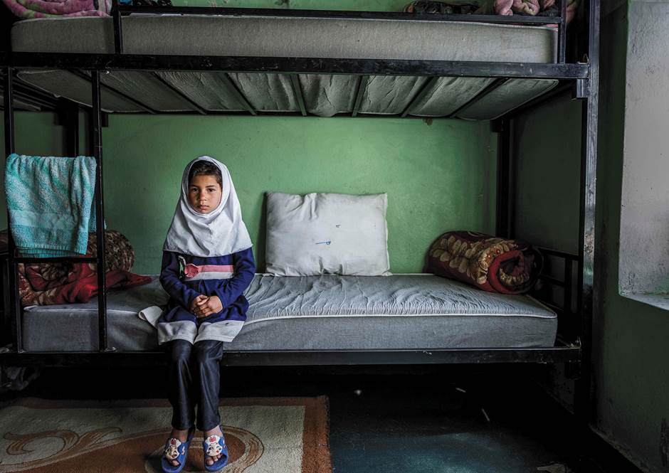 An Afghan girl sitting on her bed at Herat Orphanage Center unwilling to talk, even speak of her nam