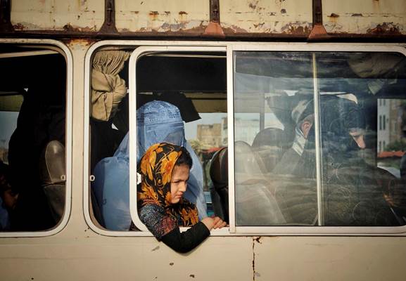 An Afghan girl with her mother while sitting on a mini-bus, June 2020, Karukh district of Herat prov