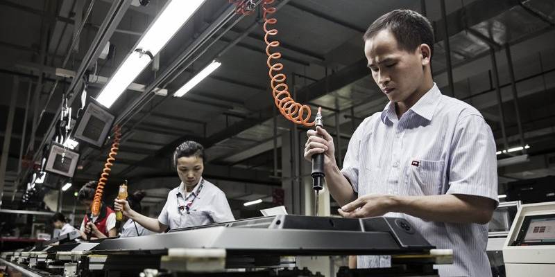 Workers assemble monitors at a factory in Huizhou, Guangdong province