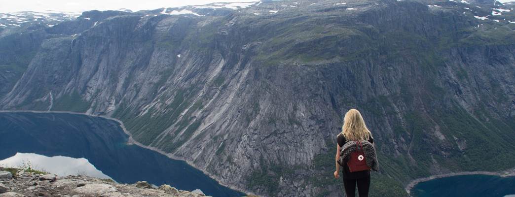 Jente på toppen av et fjell med fjordutsikt - Photo:Iben Kortegaard Rohde