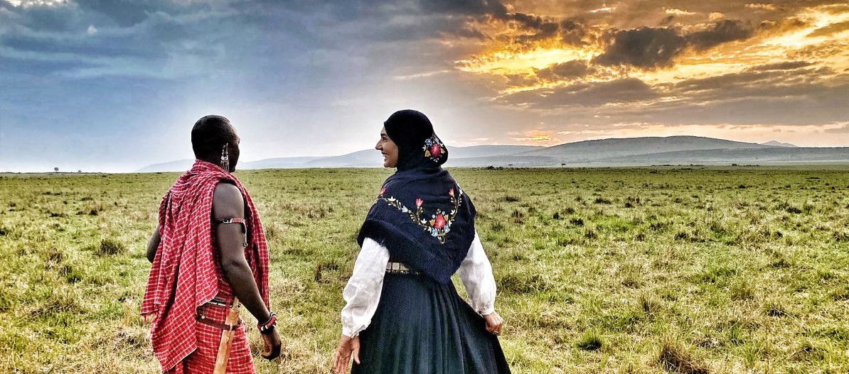 Kenyansk masai og norsk kvinne i bunad i solnedgang.  - Foto:Rhine Løvendal 