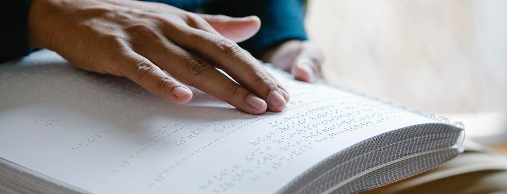 Person leser blindeskrift med hendene - Foto:Eren Li from Pexels